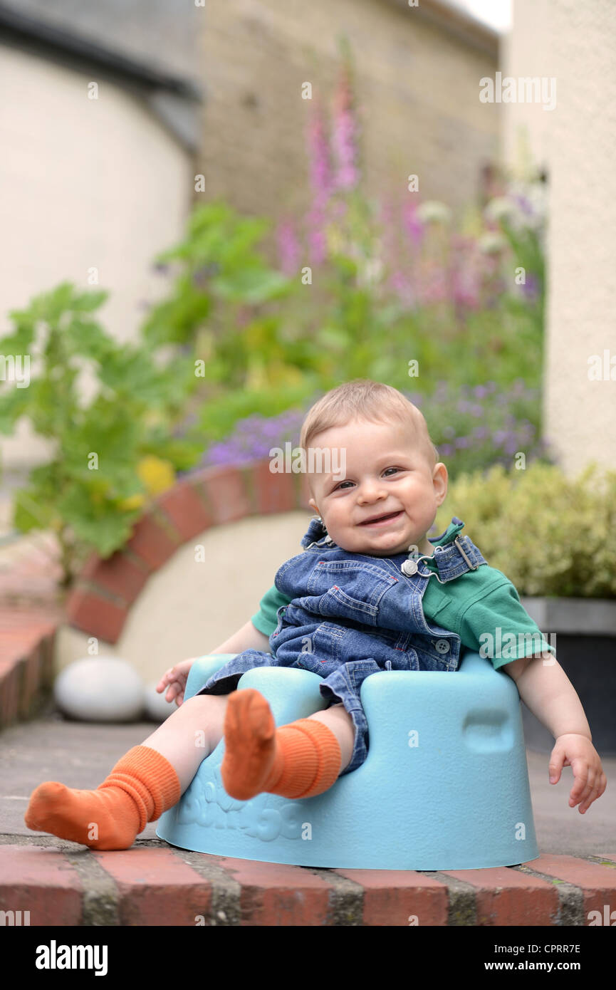 Ein acht Monate altes Baby sitzt in einem Schaum-Kindersitz UK Stockfoto