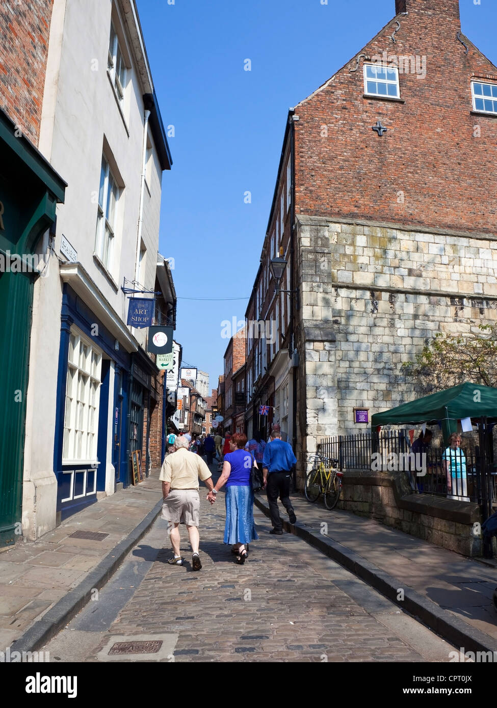 Beschäftigt Straßenszene mit Touristen zu Fuß zwischen den schiefen Gebäuden von der berühmten heilloses Durcheinander in der historischen Stadt von York Stockfoto