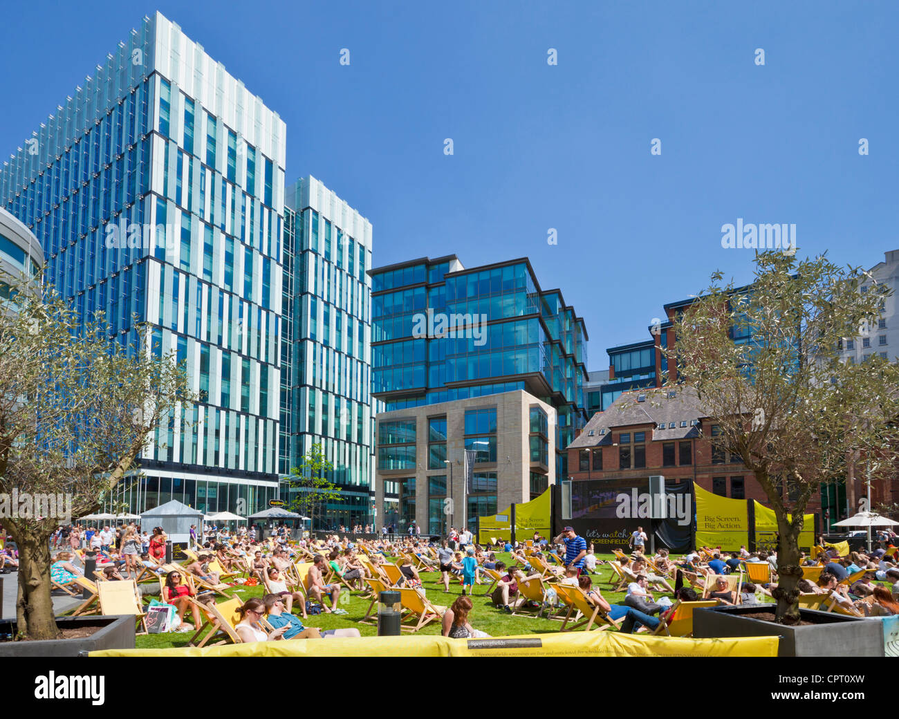 Menschenmassen genießen das warme Wetter und Sonnenschein in der Stadt Zentrum Spinningfields größere Manchester England UK GB EU Europa Stockfoto