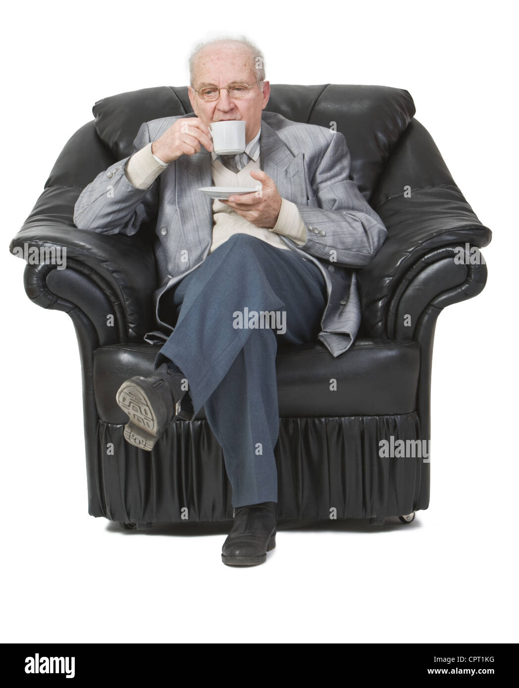 Ältere Mann trinken Kaffee Weile in einem Sessel sitzt. Stockfoto