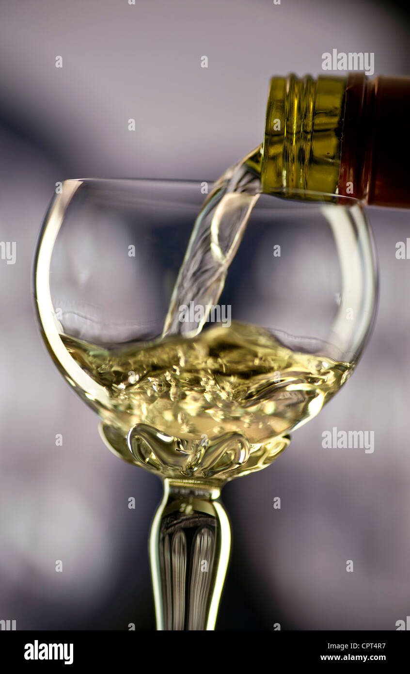 Glas Weißwein Gewürztraminer Alsace in traditionellen verzierte lange stemmed Deco Glas mit Weinfass hinter gießen Stockfoto