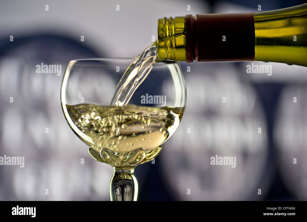 Riesling Gießen Glas weiß Rhein Wein in traditionellen verzierten Lange stammte deco Glas mit Weinfässern hinter Stockfoto