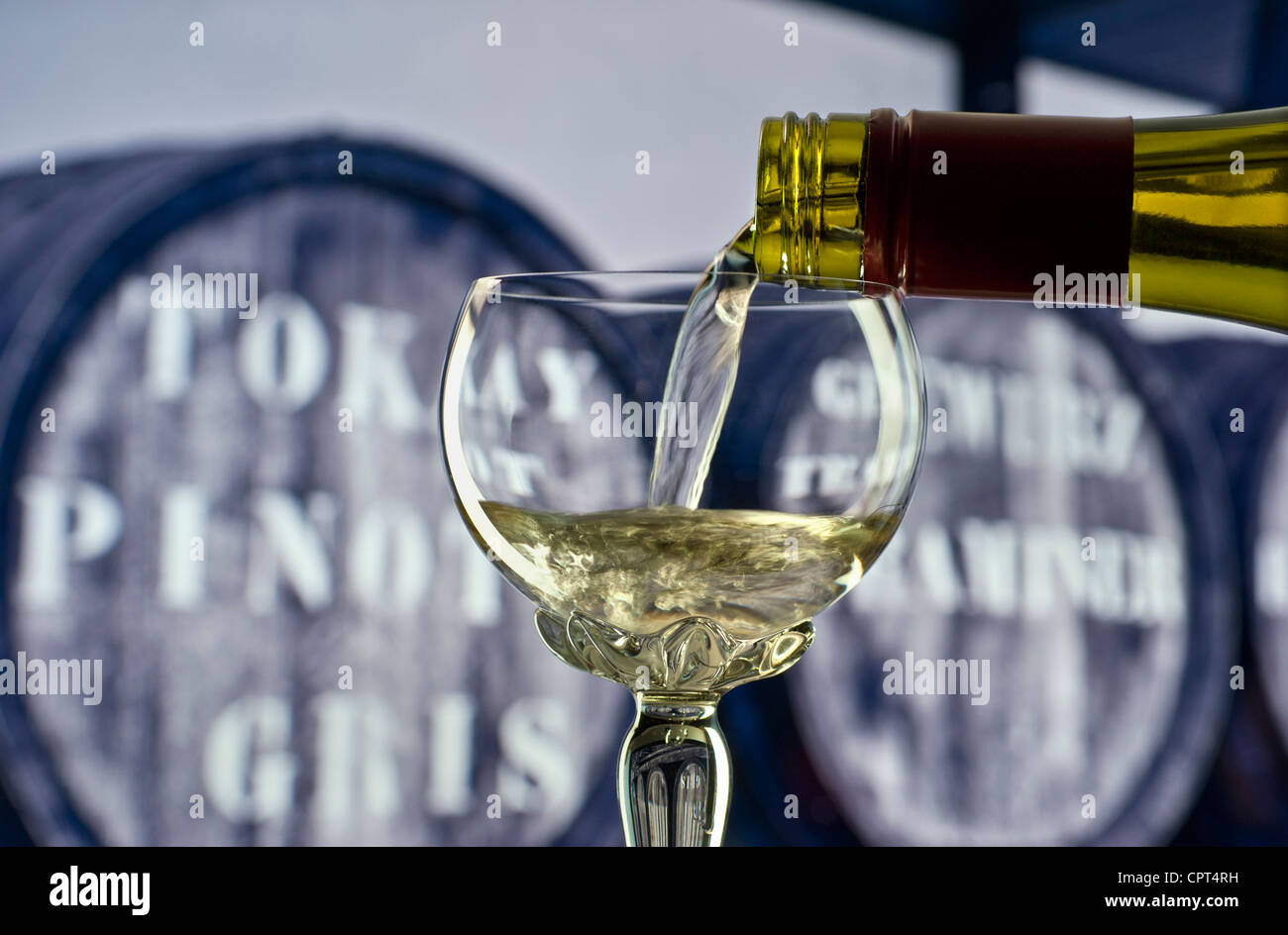 Glas Weißwein Alsace in traditionellen verzierte lange stemmed Deco Glas mit Weinfässern hinter gießen Stockfoto