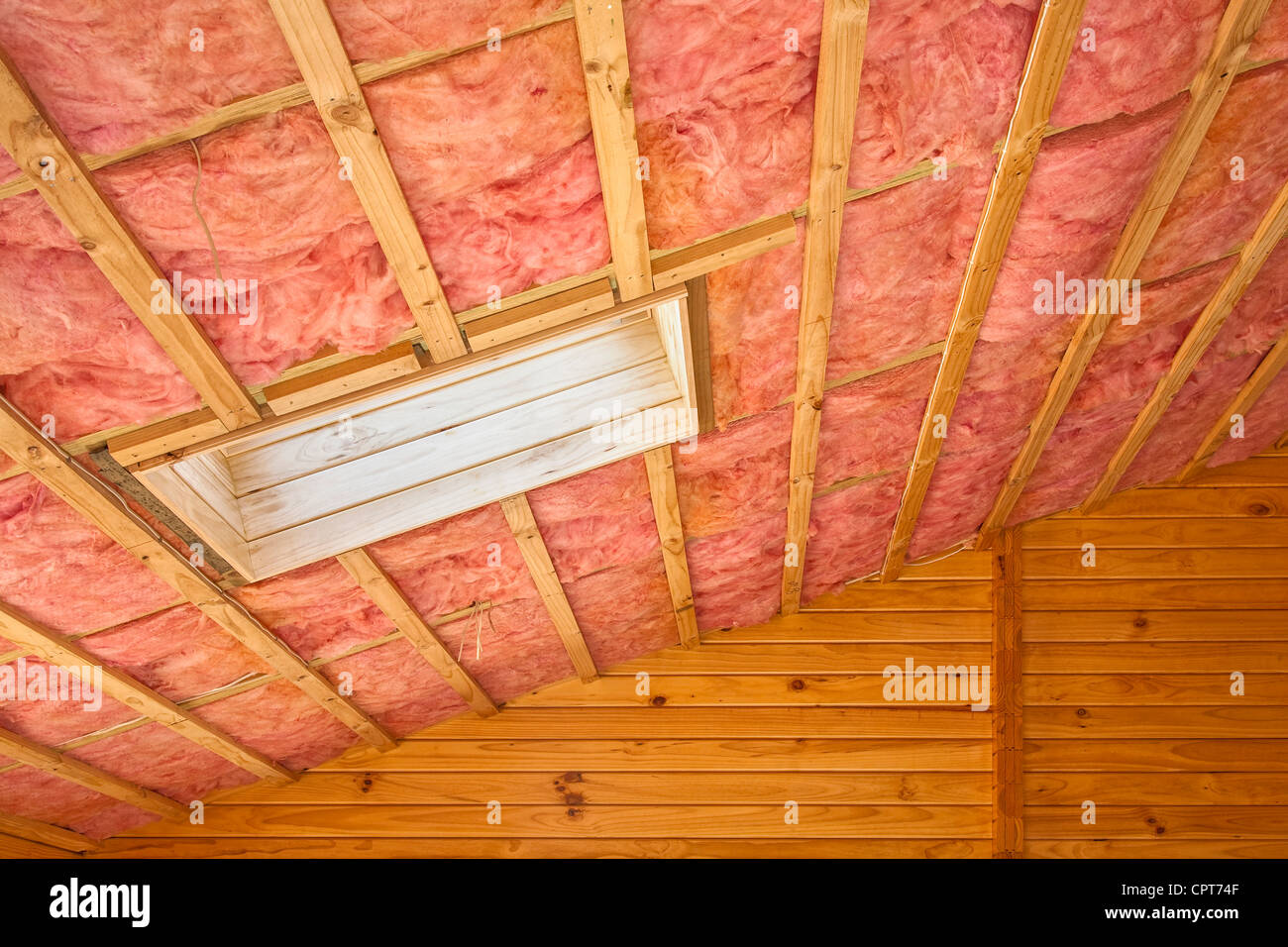 Fiberglas Isolierung in der Dachschräge eines Holzhauses installiert. Stockfoto