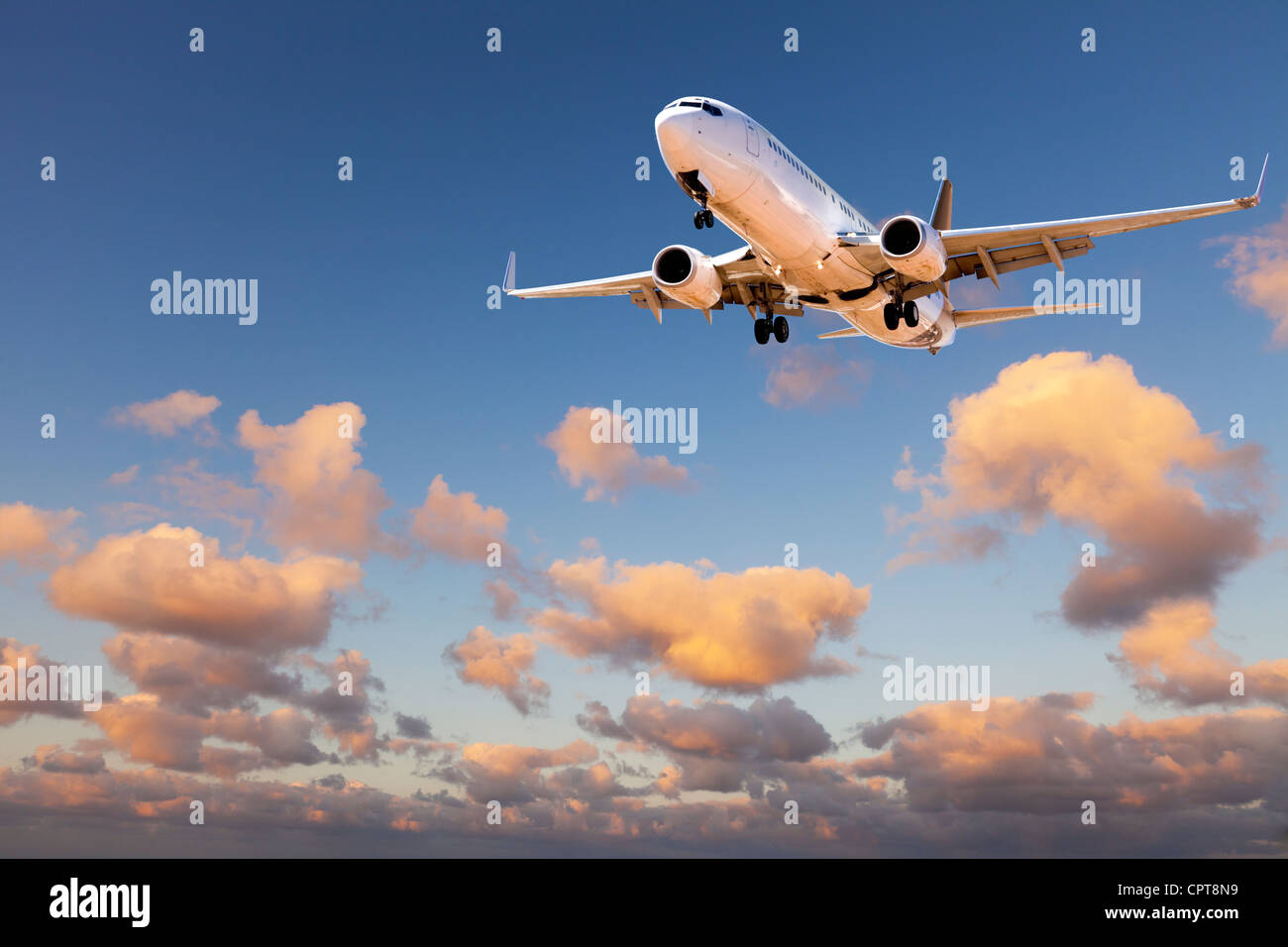 Boeing 737 kommen im Sonnenuntergang Himmel zu landen. Stockfoto