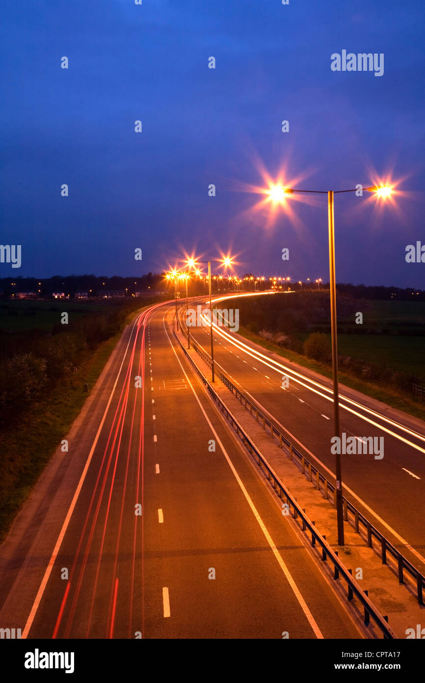 Straße in der Nacht mit Verkehr Trails und Straßenlaternen Stockfoto