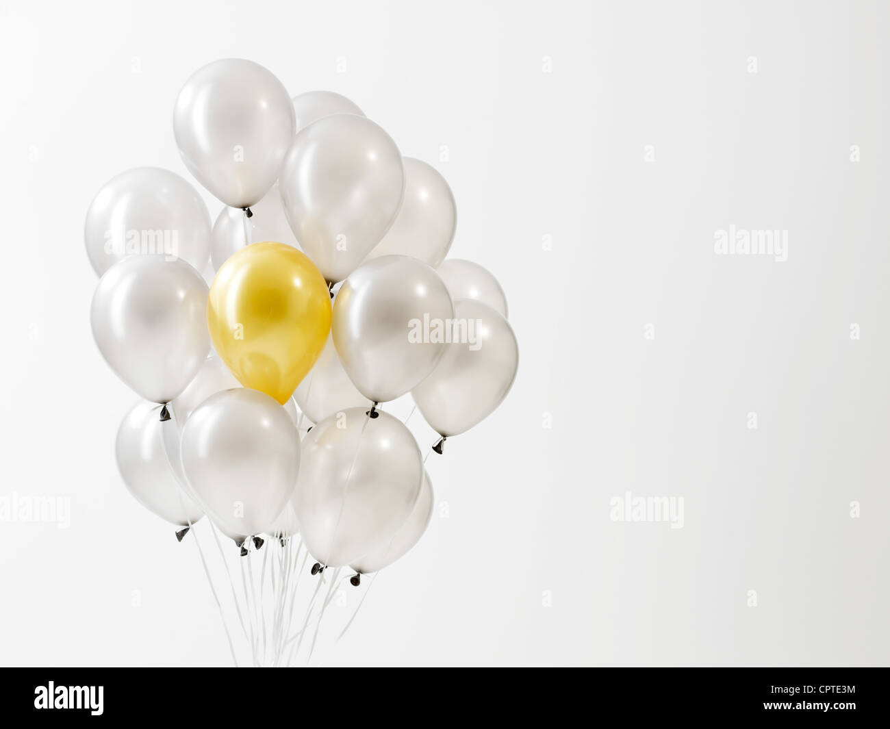 Goldkugel in silbernen Ballons vor weißem Hintergrund Stockfoto