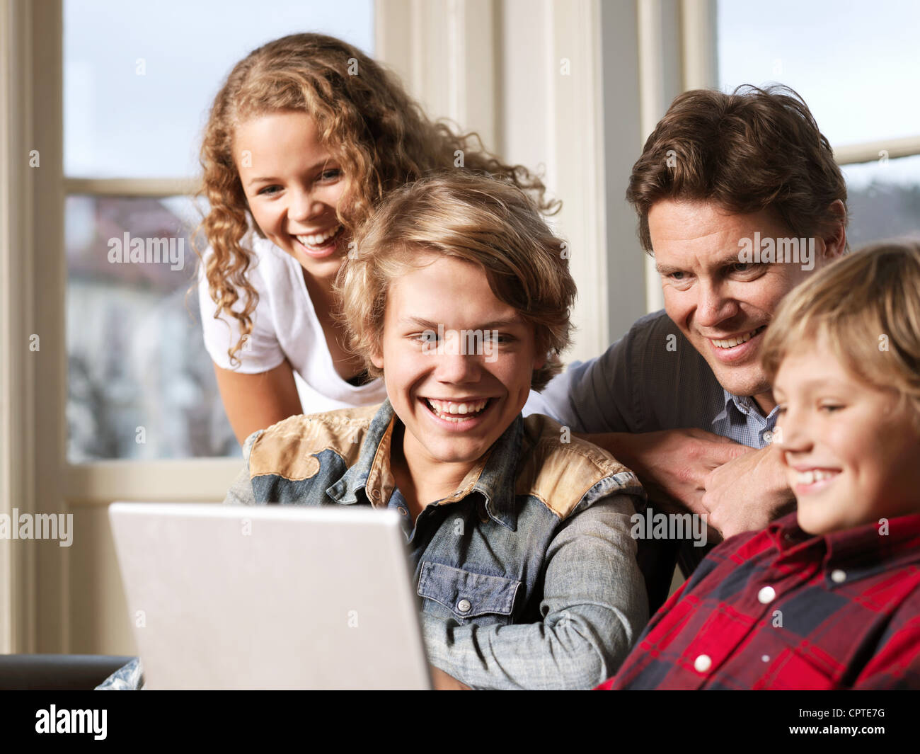 Vater beobachtete Laptop mit Söhnen und seiner Tochter auf sofa Stockfoto