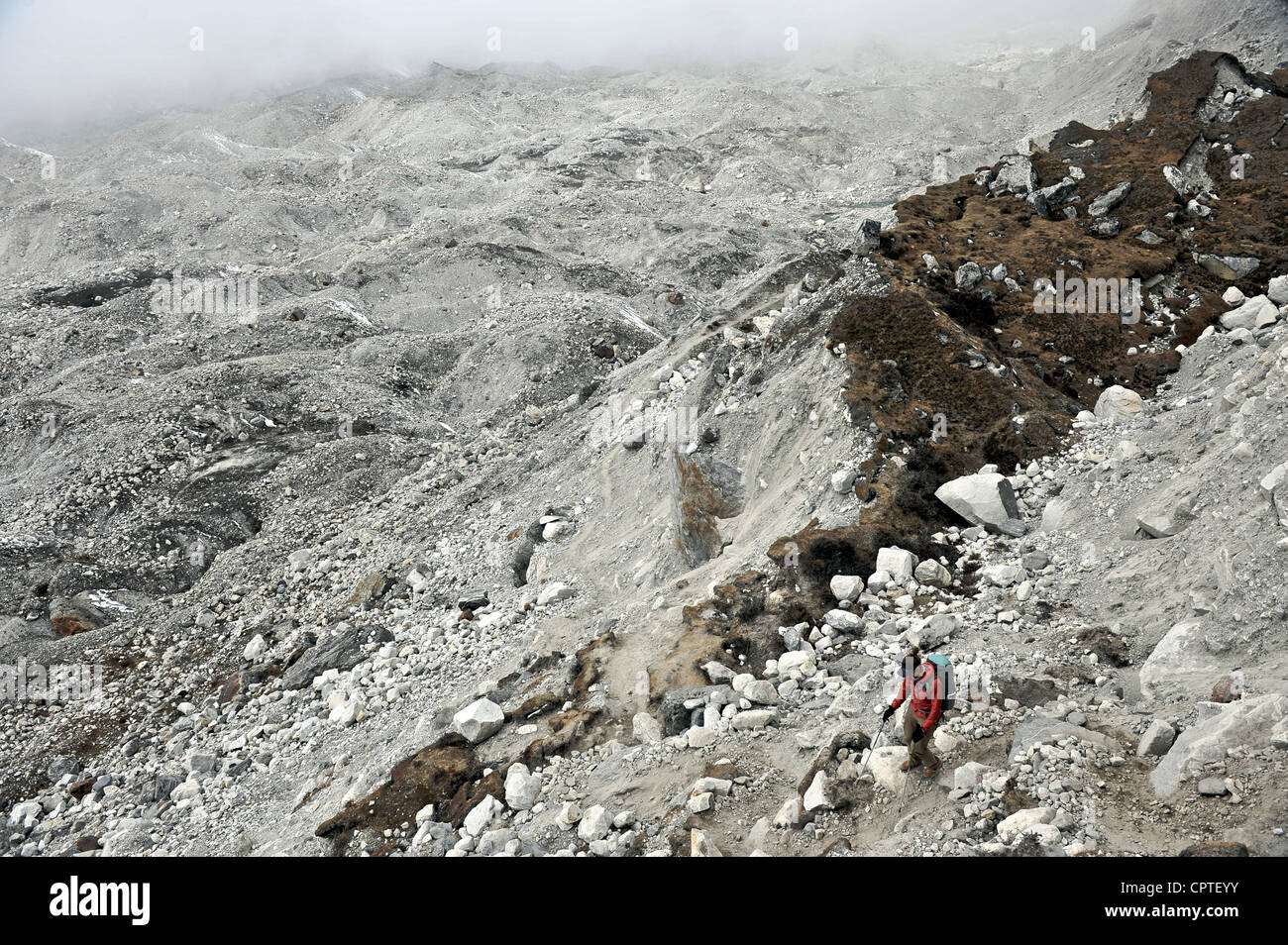 Weibliche Trekker absteigend über die Moräne des Nguzumpa Gletschers, Nepal Stockfoto