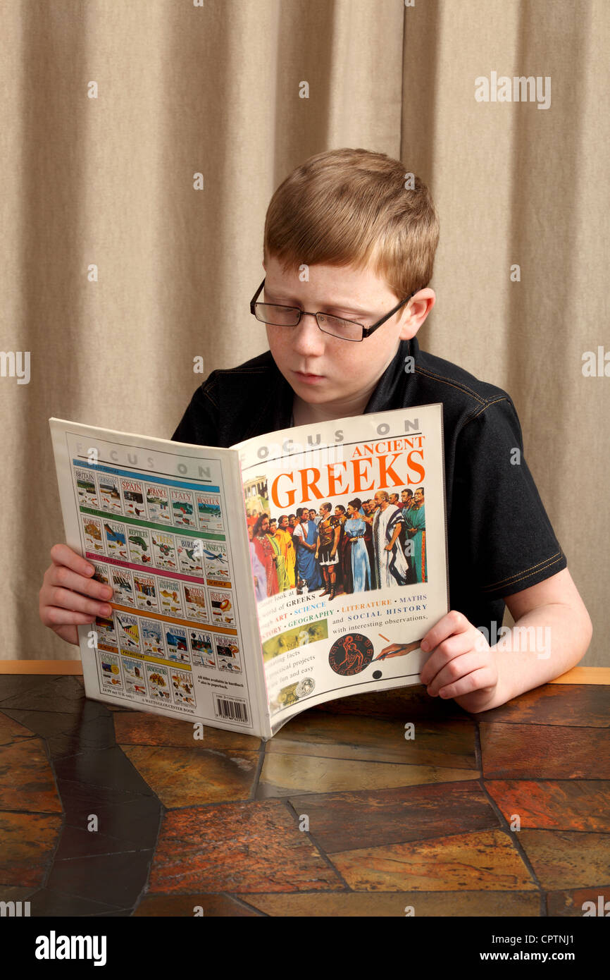 Ein zwölf Jahre alter Junge liest ein Buch über die alten Griechen. Das Buch ist nicht mein copyright Stockfoto