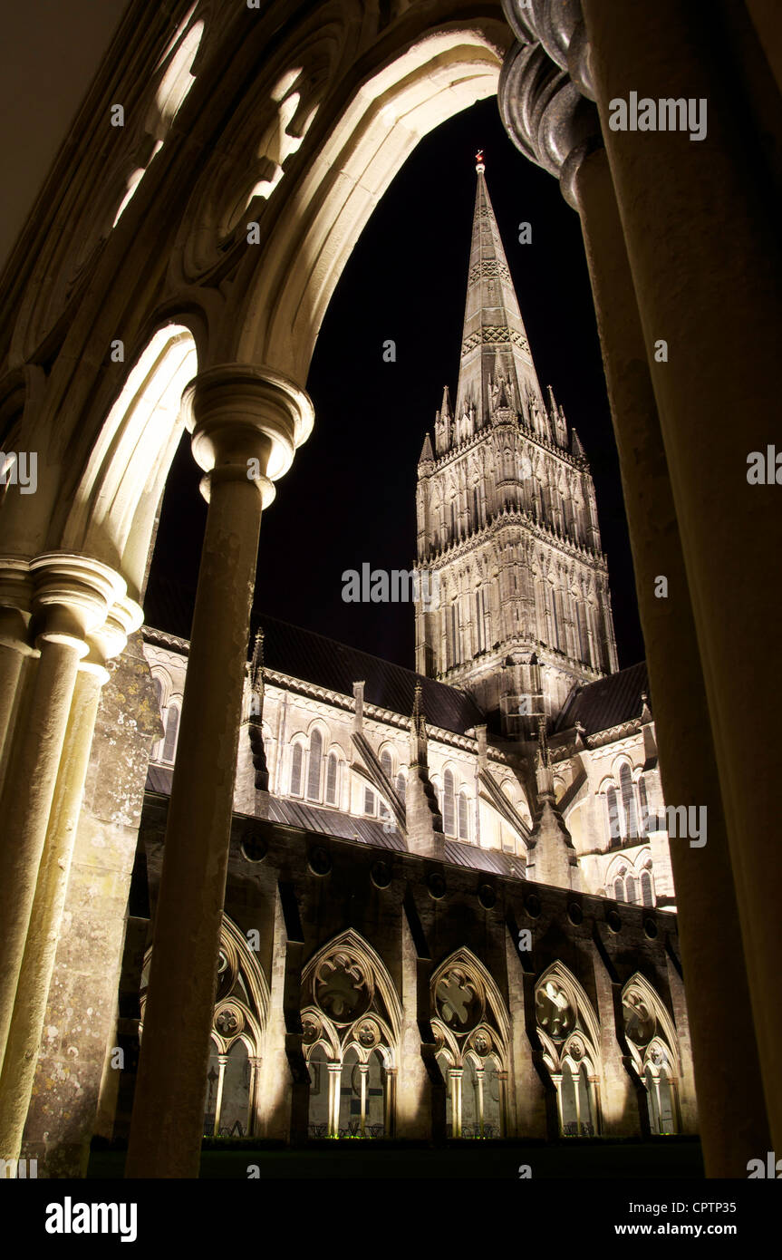 Der elegante Turm der Kathedrale von Salisbury auf Flutlicht den Himmel gesehen in der Nacht durch einen Bogen von der Kreuzgang. Stockfoto
