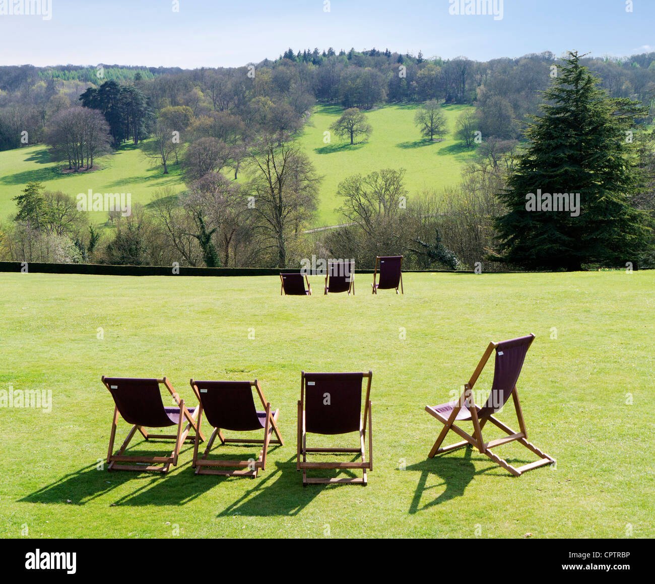 Liegestühle und Bäume auf dem Gelände des Polesden Lacey Gärten, Surrey Stockfoto