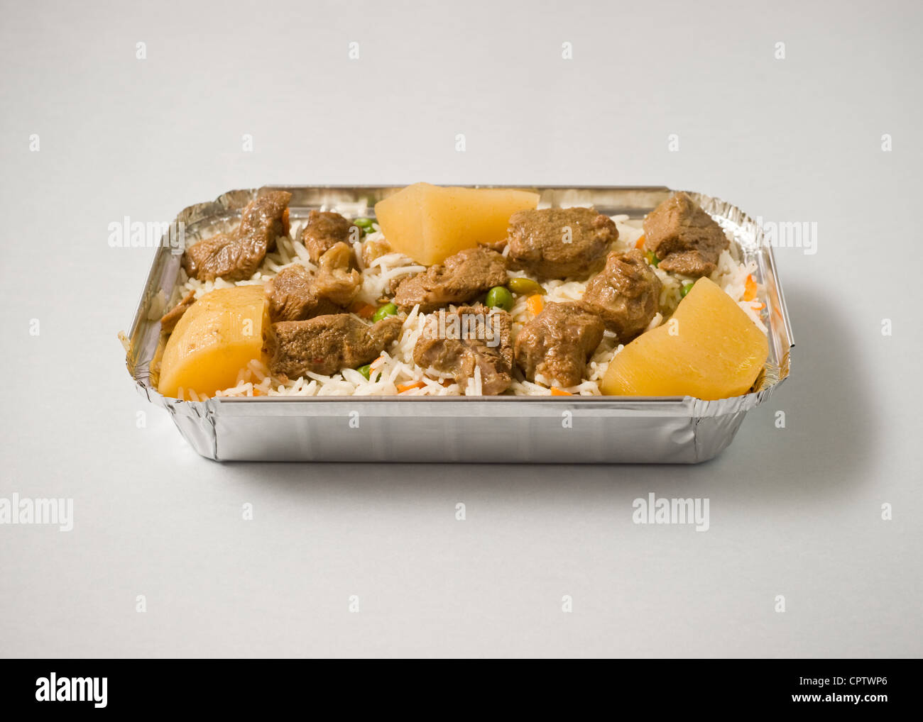 Reis mit Rindfleisch und Kartoffeln in einer Folie Box zum mitnehmen Stockfoto