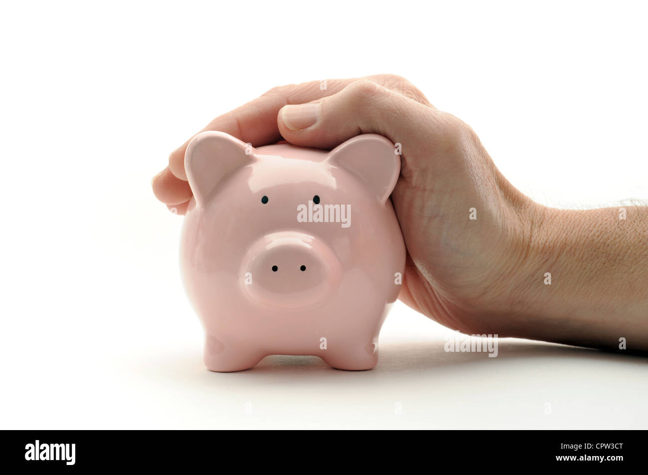 SPARSCHWEIN PIGGY BANK GESCHÜTZT DURCH MANS HAND RE EINKOMMEN LÖHNE EINSPARUNGEN ZINSSÄTZE RENTEN RUHESTAND LEBENSHALTUNGSKOSTEN RECHNUNGEN UK Stockfoto