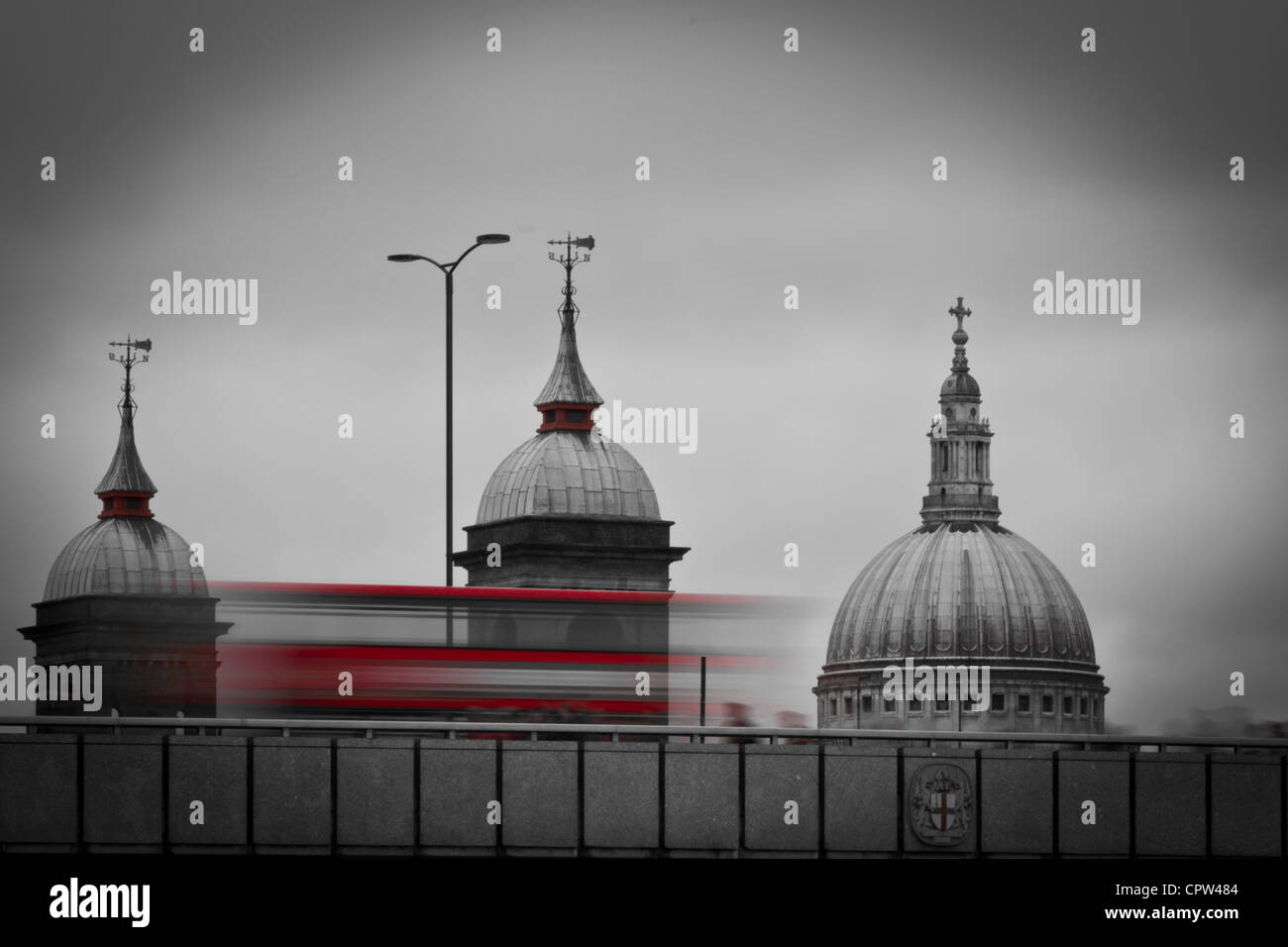 Ikonische London Red Bus überquert London Bridge mit St. Pauls Kathedrale in der Ferne. Stockfoto