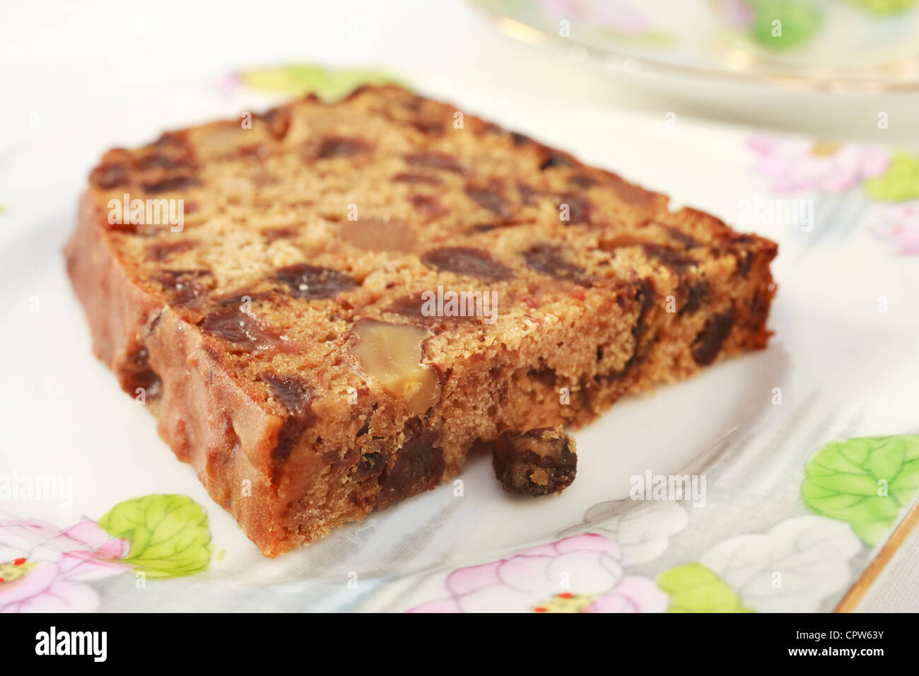Ein Frucht-Kuchen mit Walnüssen enthält kein Fett, bekannt als irischer Tee Brot. Auf ziemlich floral Geschirr für den Nachmittagstee. Stockfoto