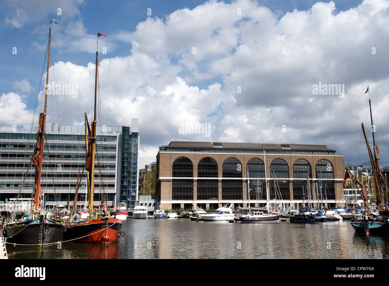 Hölzerne Segeln Schiffe stehen im Kontrast zu modernen Gebäuden und Yachten im St. Katherine Docks, London, UK Stockfoto