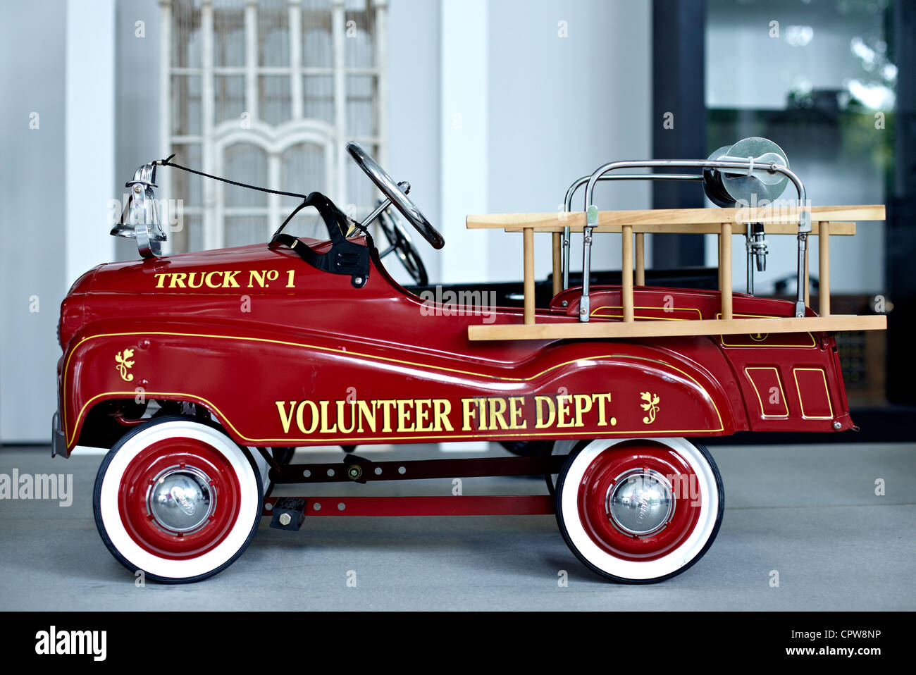 Child's Antique rotes Spielzeugpedalauto auf Basis eines amerikanischen Feuerwehrautos. Stockfoto
