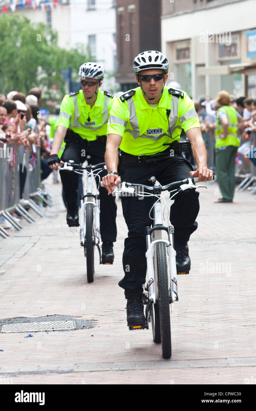 Polizei-Sicherheit auf dem Fahrrad in der Straße vor einem Lauf Abergavenny, Wales, UK Stockfoto