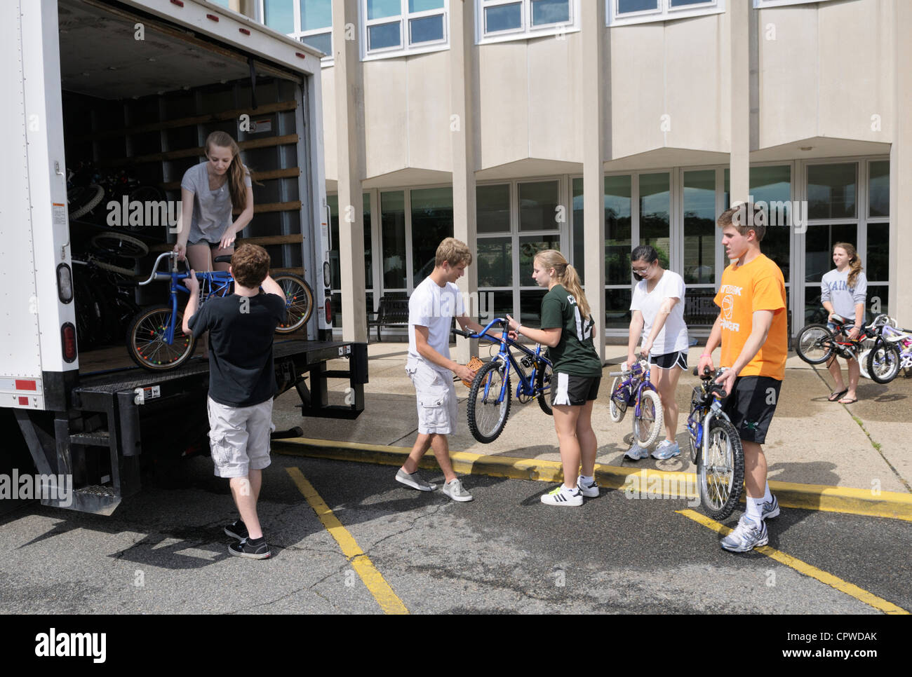 High School Student freiwilligen Zivildienst laden tun gespendet gebrauchte Fahrräder auf LKW, für die armen Länder zu verteilen. Stockfoto