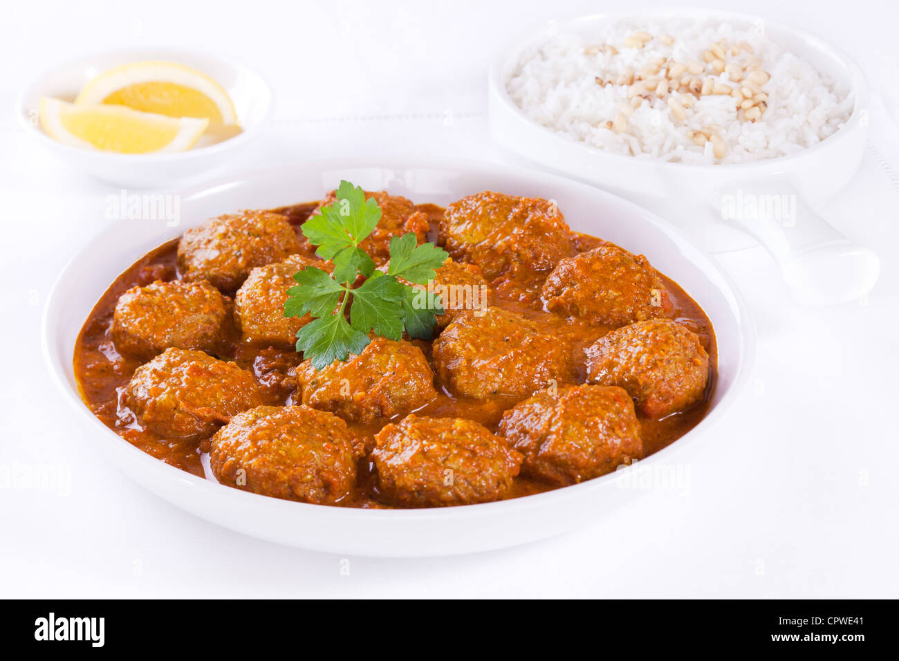 Indisch-Hackfleischbällchen in Curry-Sauce mit Basmati-Reis und Pinienkernen. Stockfoto