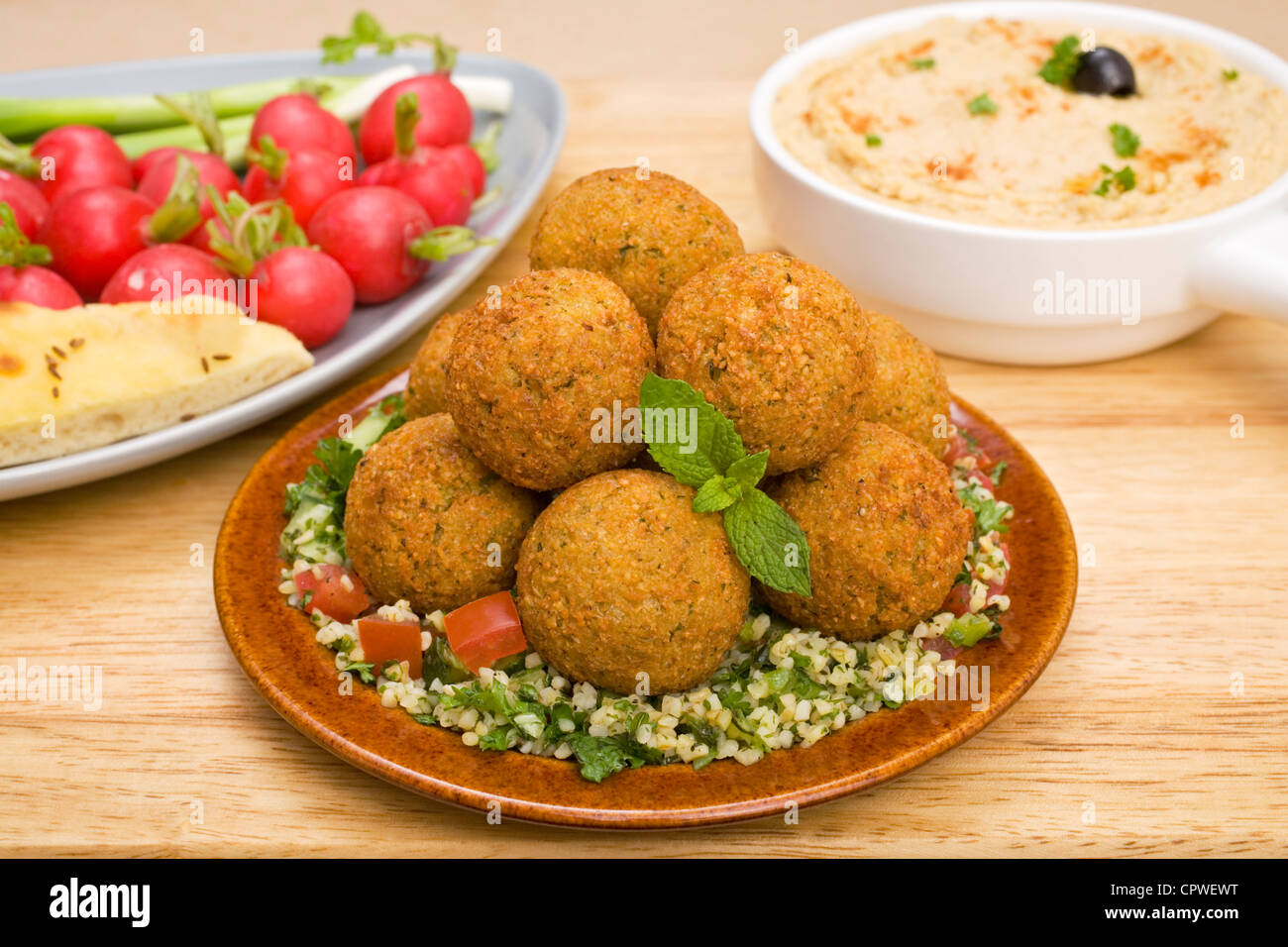 Nahen Osten behandelt, Falafel, sitzt auf einem Bett von Taboulé mit Hummus und Radieschen. Stockfoto