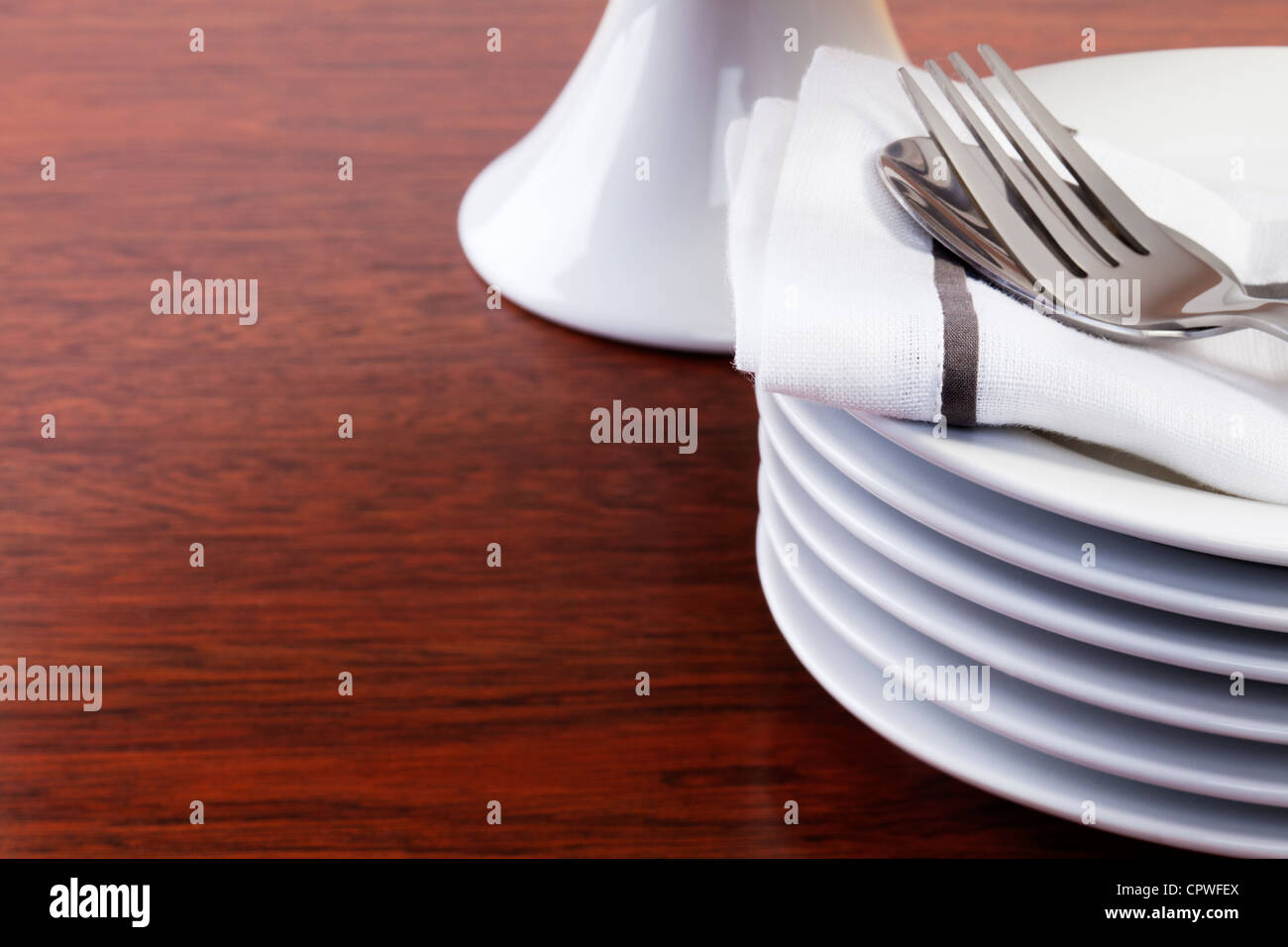 Stapel von kleinen oder Dessert Teller auf einer dunklen Eiche Oberfläche, Etagere im Hintergrund. Stockfoto