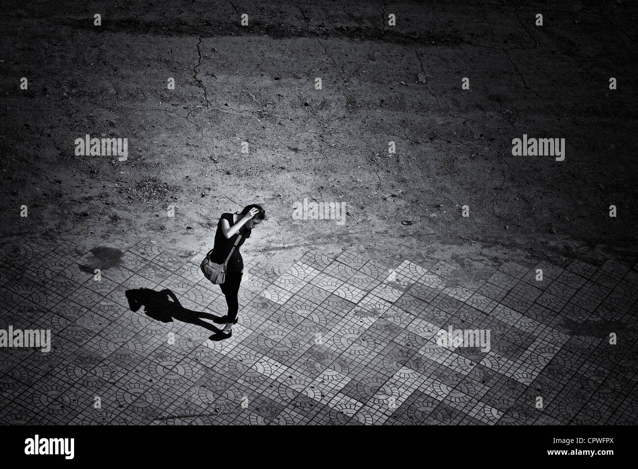 Frau allein in der Nacht mit ihrem Schatten Schwarz und Weiß Fotografie Stockfoto
