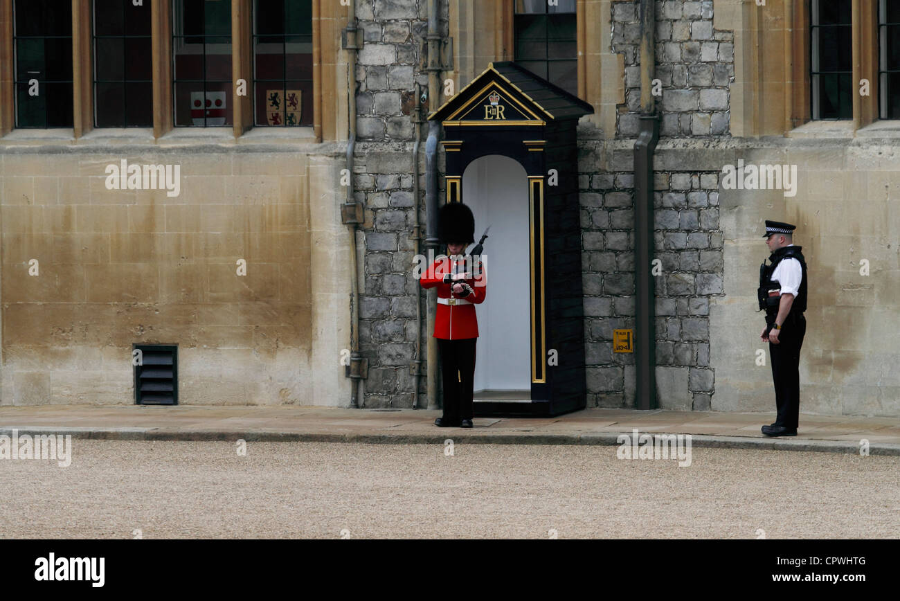 Windsor castle - The Upper Ward State Apartments - Coldstream Gardist auf Wache beobachtet von einem bewaffneten Polizisten Stockfoto