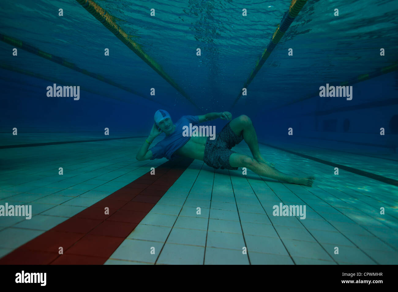 Glücklicher Mann ruht auf der Pool-Boden - Unterwasser-Shooting Stockfoto