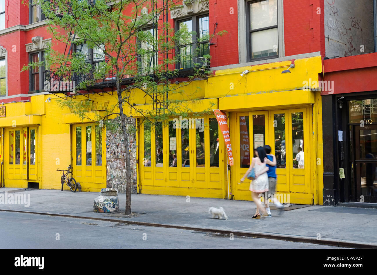 Paar, Hund auf Bürgersteig im New Yorker Stadtteil East Village Nachbarschaft spazieren gehen. Stockfoto