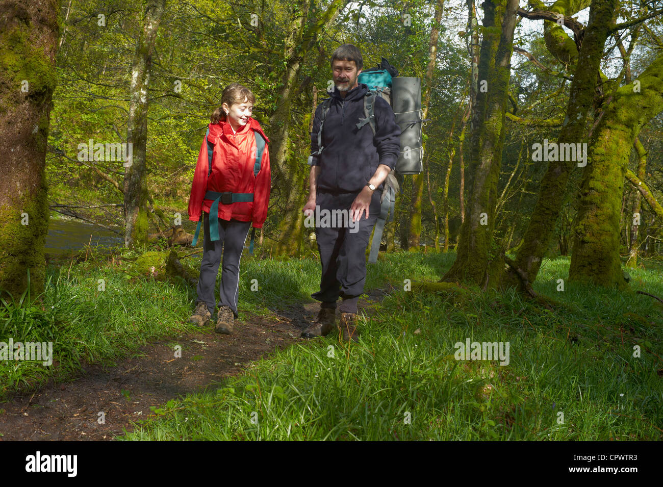 Vater und Tochter zu Fuß mit Campingausrüstung vom Fluss dart in der Nähe von Newbridge Dartmoor Nationalpark England Stockfoto
