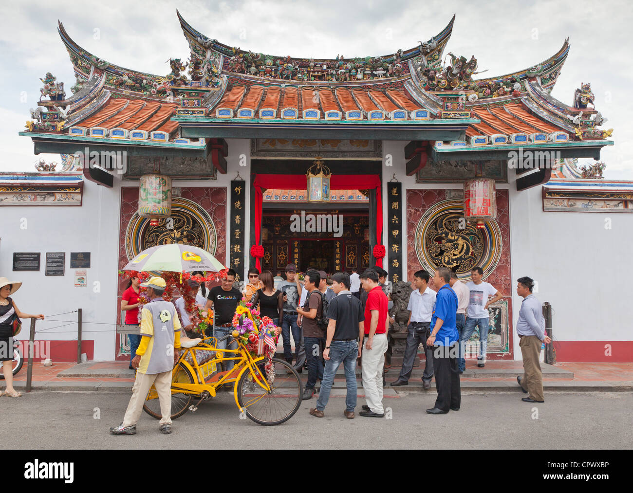 Bunte Fahrradrikscha mit Touristen, Cheng Hoon Teng (grüne Wolken Tempel) Tempel, Malacca, Malaysia. Stockfoto