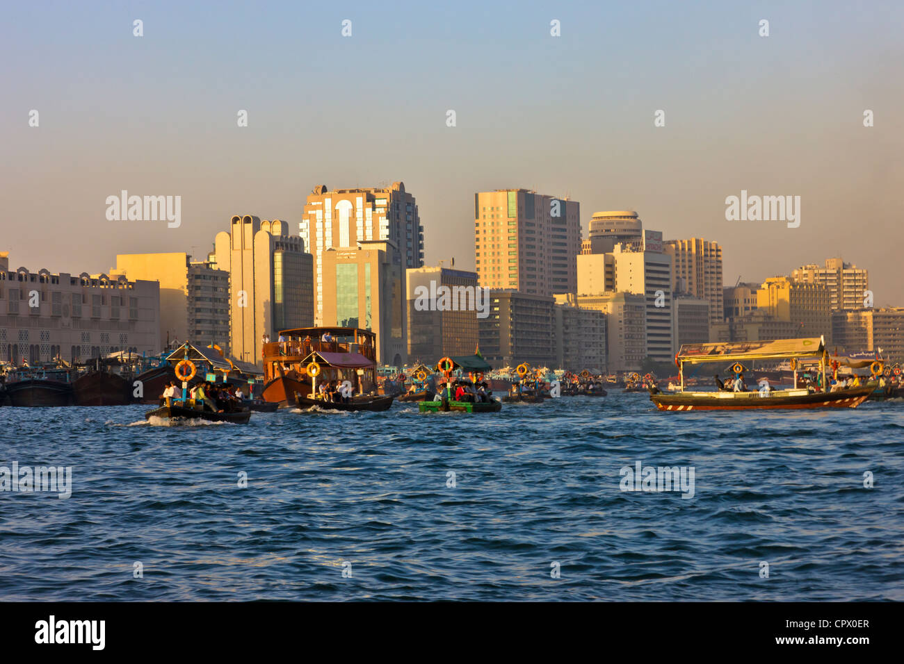 Fähren und Skyline entlang Khor Dubai (Dubai Creek), Dubai, Vereinigte Arabische Emirate Stockfoto