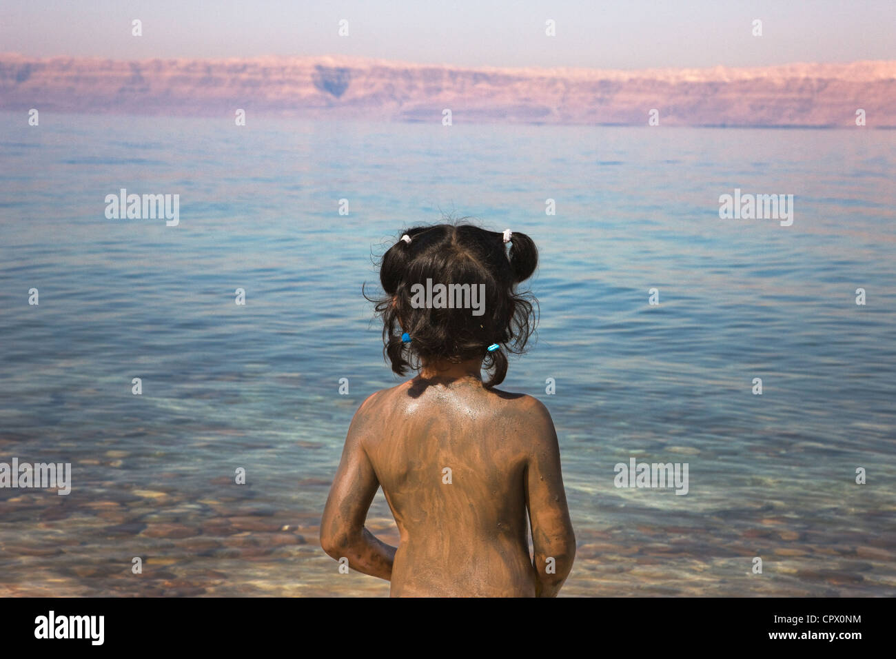 Mädchen bedeckt mit Schlamm vom Toten Meer, Jordanien Stockfoto