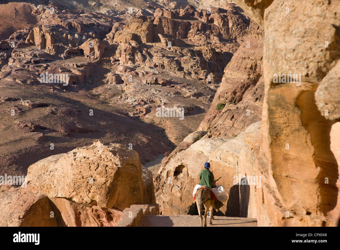 Mann reitet auf Esel in den antiken Ruinen von Petra, Jordanien (UNESCO-Weltkulturerbe) Stockfoto