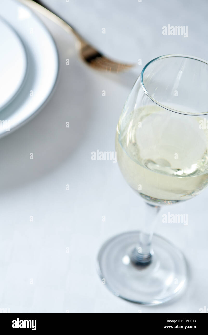 Glas Weißwein auf Tisch Stockfoto