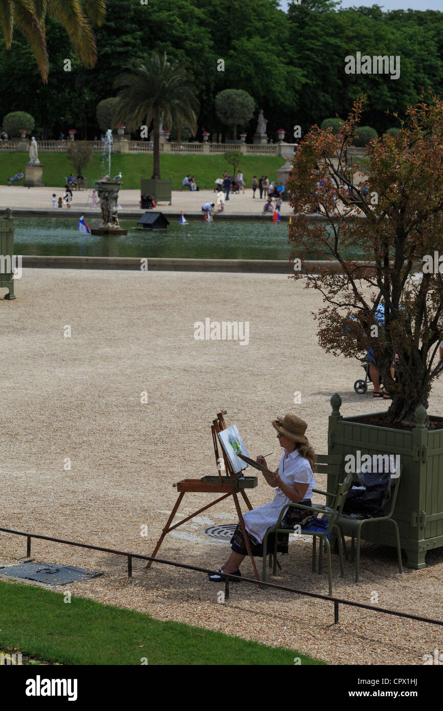 Jardin du Luxembourg, Paris. Die 60 Hektar großen Gärten sind die beliebtesten in Paris. Ein Künstler sitzt an einem Nachmittag im Juni Malerei. Stockfoto