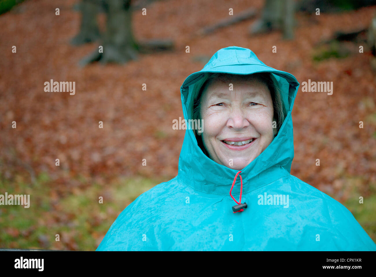 Ältere Frau tragen wasserdichte Kleidung und lächelnd Stockfoto