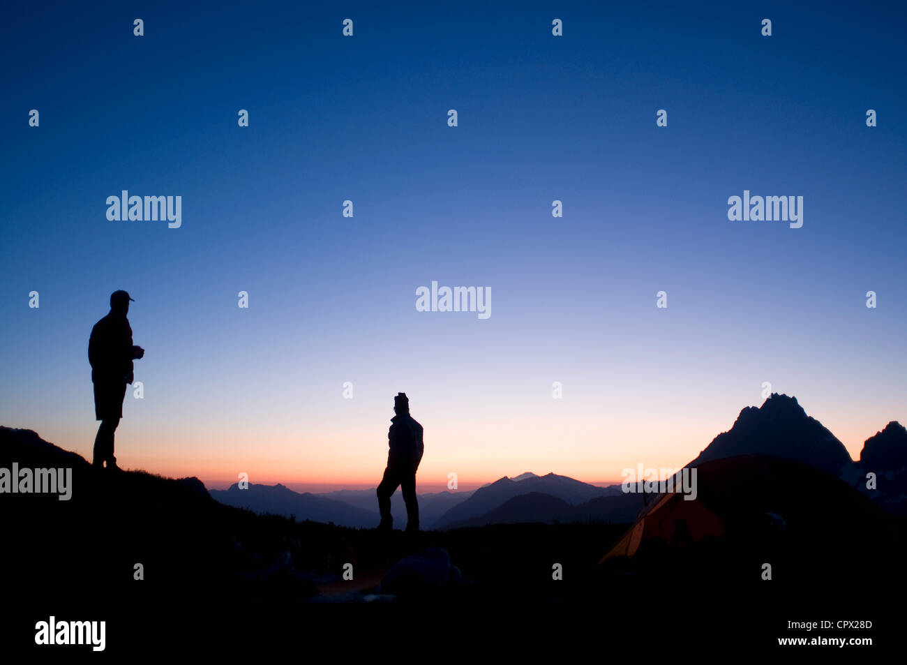 Männliche Rucksacktouristen im Camp in den Abend, Kool-Aid-See, Ptarmigan Traverse, North Cascades, Washington, USA Stockfoto