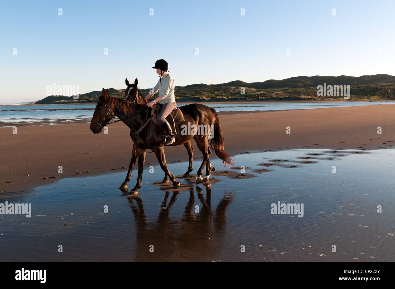 Junge Frau Reiten am Strand Stockfoto