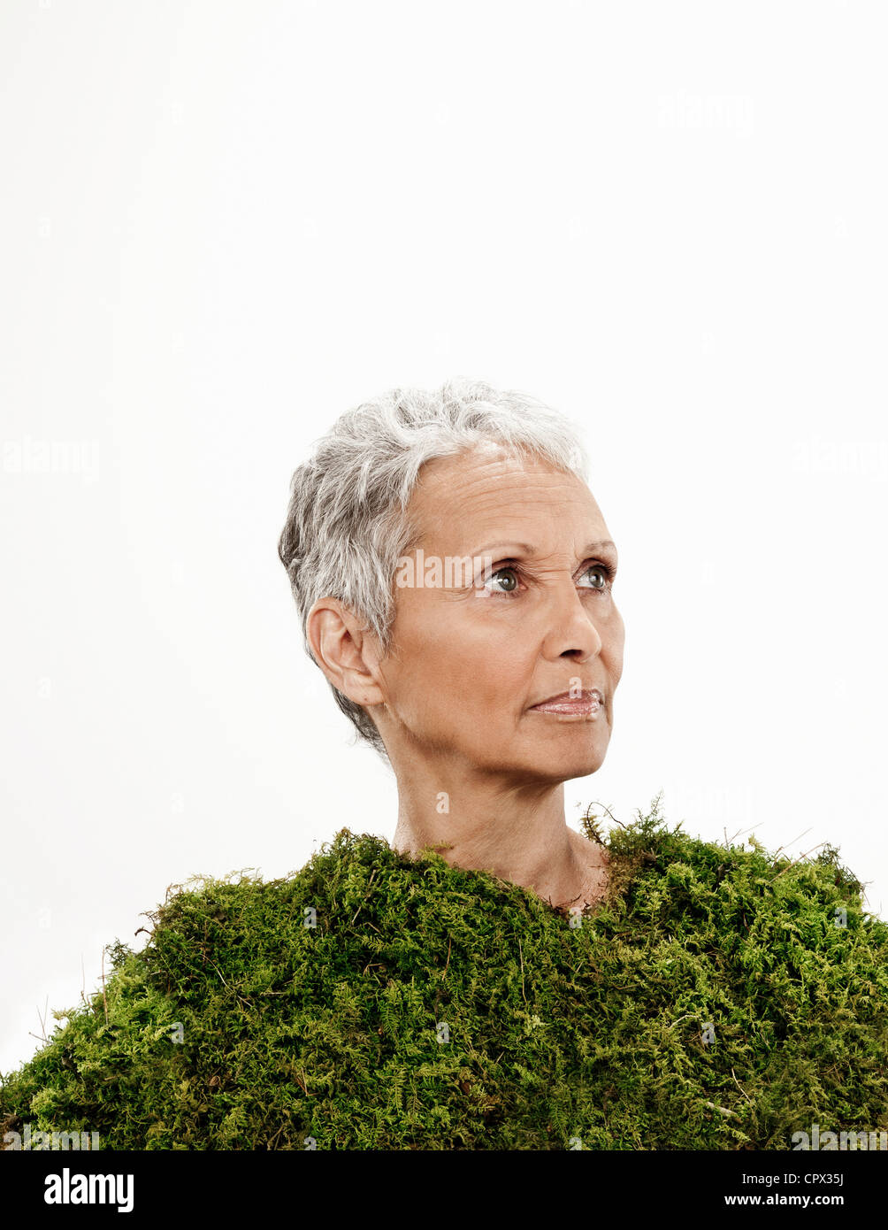 Ältere Frau eingewickelt in Moos Stockfoto