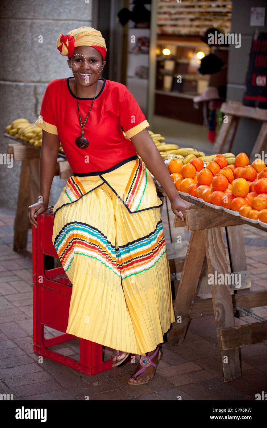 Straßenhändler, gekleidet in traditioneller Kleidung lächelt in die Kamera Stockfoto