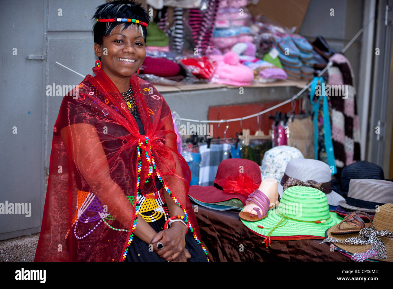 Straßenhändler, gekleidet in traditioneller Kleidung lächelt in die Kamera Stockfoto
