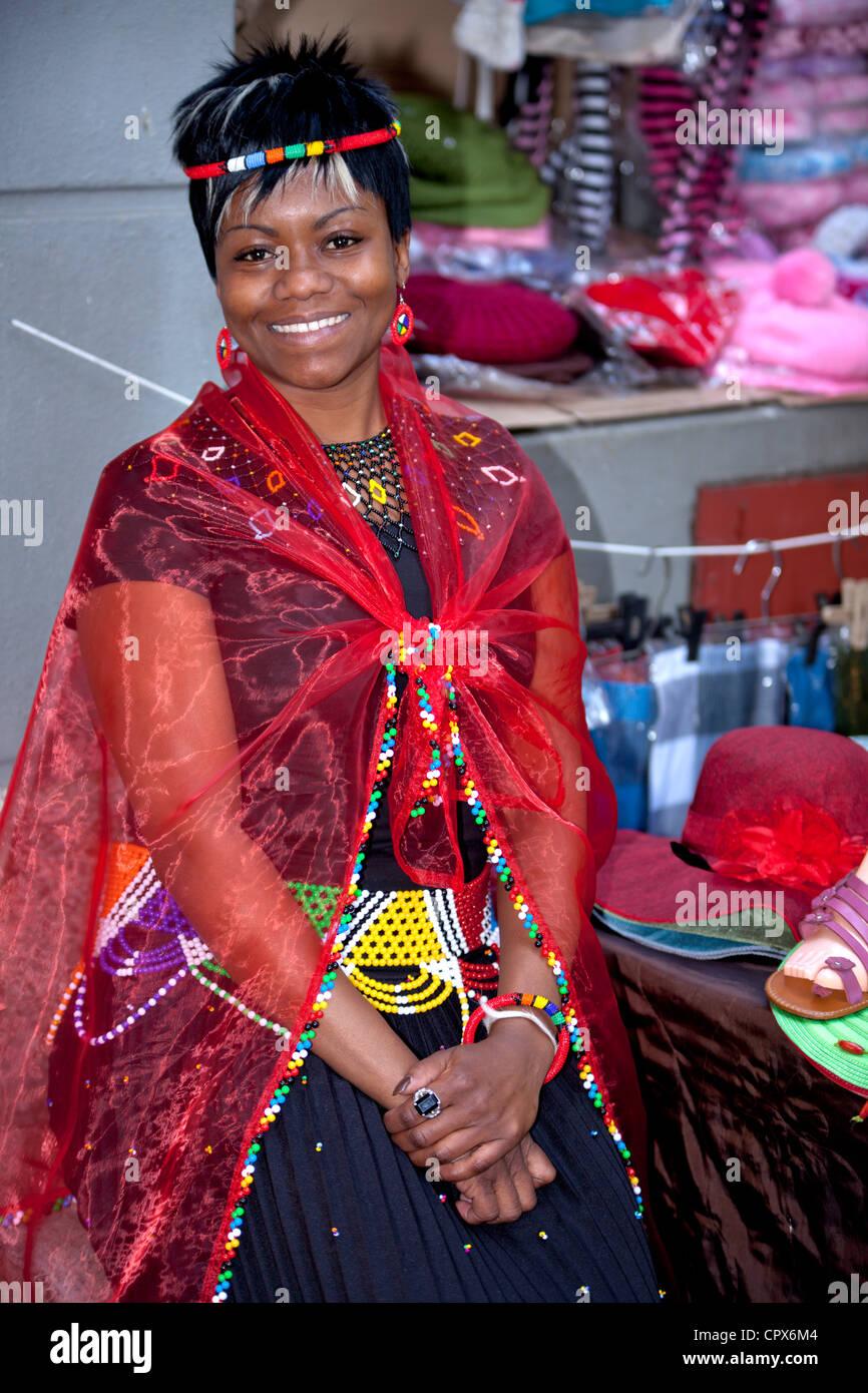 Straßenhändler, gekleidet in traditioneller Kleidung lächelt in die Kamera Stockfoto