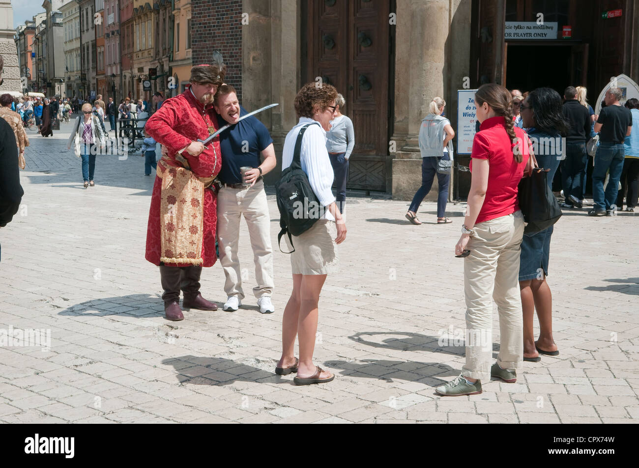 Mann mit historischen Kleid posiert für Fotos mit Touristen. Hauptmarkt, Krakau, Polen. Stockfoto