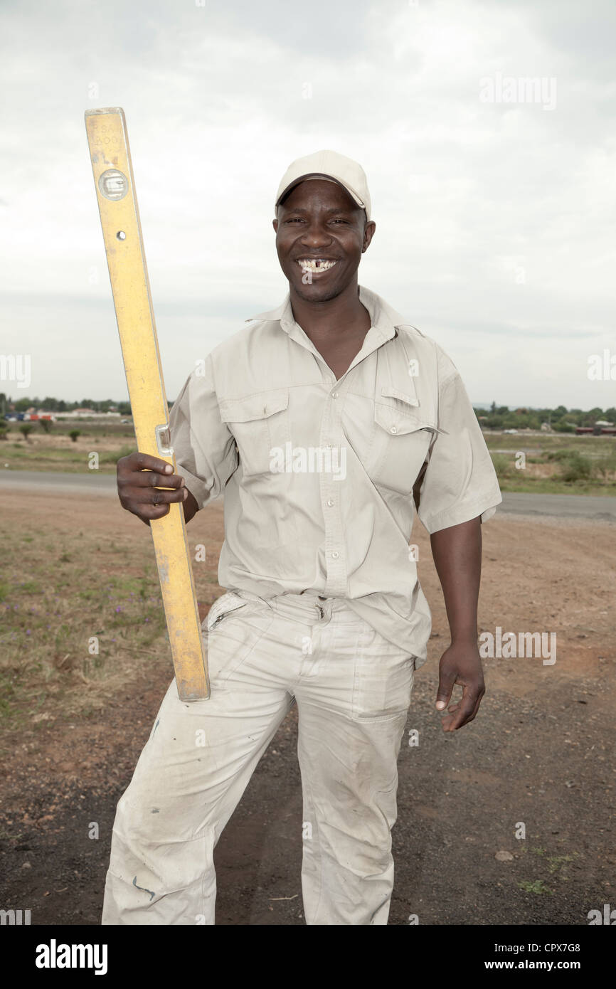 Schwarzen Bauarbeiter posiert mit Wasserwaage Stockfoto