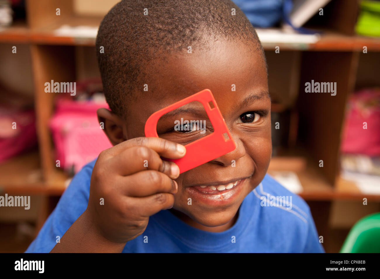 Kind auf der Suche durch Spielzeug Rahmen, Lächeln Stockfoto