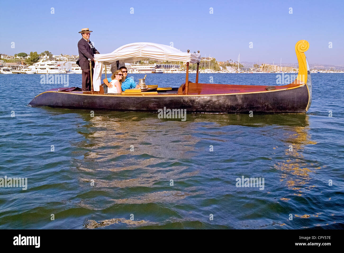 Romantische Gondelfahrt mit einer singenden Gondoliere reitet, Champagner, Pralinen und Blumen im Hafen von Newport in Newport Beach in Kalifornien, USA angeboten. Stockfoto