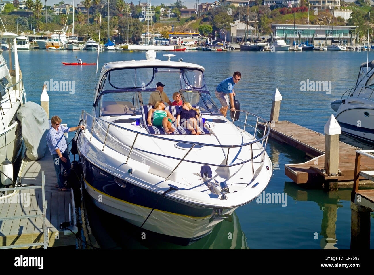 Ein Yachting-Familie und ihre Freunde aus ihrer privaten Lido Isle abketten dock für eine Kreuzfahrt in den Pazifischen Ozean in Newport Beach, Kalifornien, USA. Stockfoto